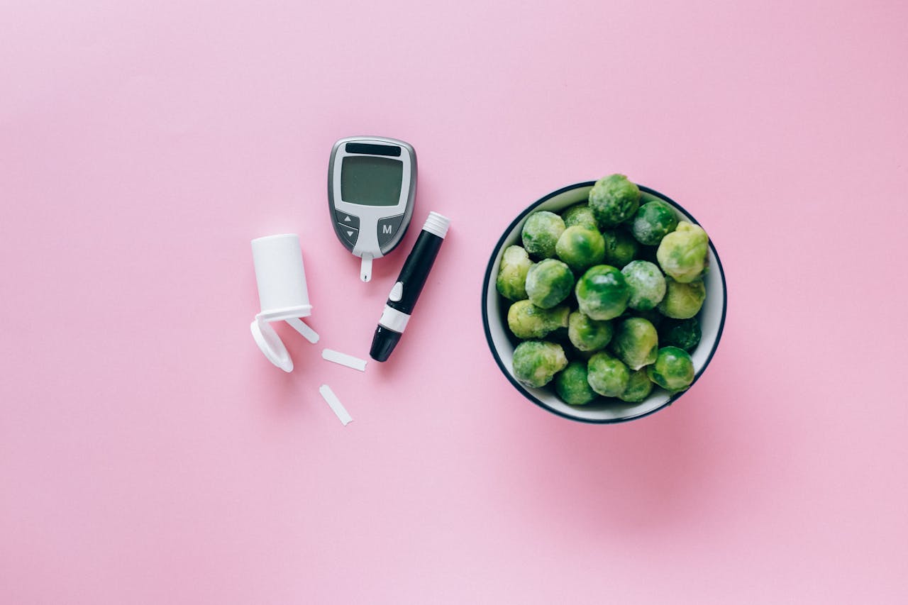 about-01 Top view of a glucometer and fresh Brussels sprouts on a pink background promoting health.